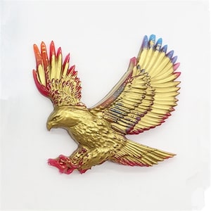 May include: A gold eagle sculpture with red, orange, blue, and purple accents on the wings. The eagle is in flight with its wings spread wide.
