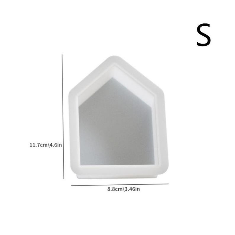 Op de afbeelding: Witte siliconen mal in de vorm van een huis met een hoogte van 11,7 cm en een breedte van 8,8 cm. De mal is gemarkeerd met de letter "S".