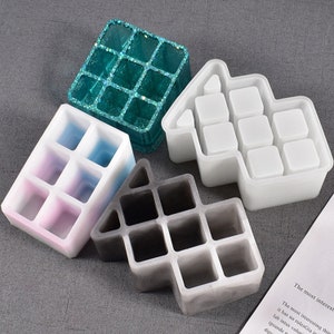 May include: Four silicone molds for making resin crafts. The molds are shaped like houses with multiple square compartments. The molds are in different colors: teal, white, pink and gray.