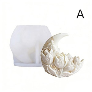 May include: A white, crescent-shaped candle with a floral design, featuring detailed tulip-like blossoms. The candle has gold flecks and a wick. A white, hexagonal mold is to the left of the candle. The letter "A" is in the upper right corner.