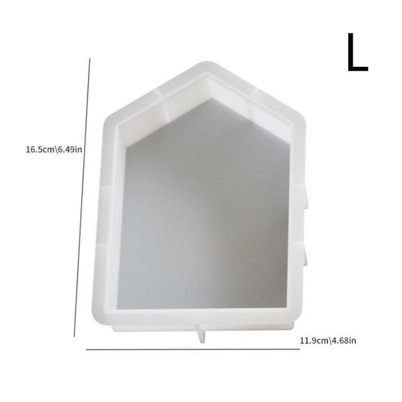 Op de afbeelding: Witte plastic mal voor het maken van betonnen stapstenen. De mal is gevormd als een huis met een puntdak. De mal is 16,5 cm hoog en 11,9 cm breed.