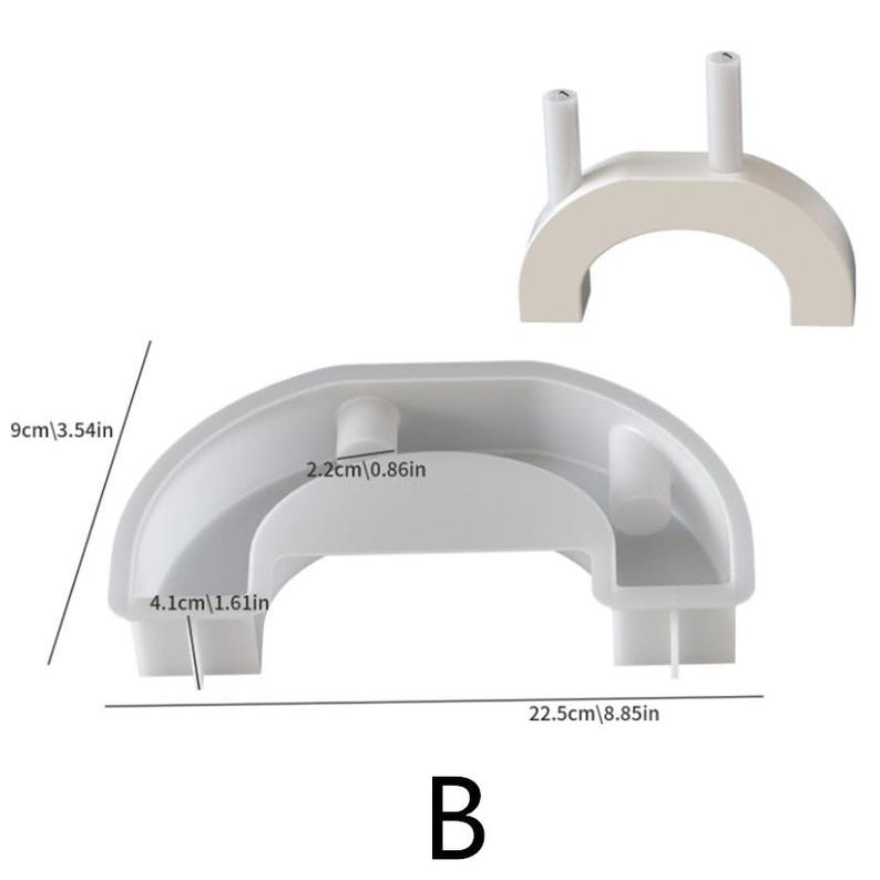May include: Two-piece, light gray, arched mold for crafting. The larger piece is 22.5 inches long and 9 inches high, with a smaller, matching piece above. The mold has a rounded shape with cylindrical posts. The letter "B" is at the bottom.
