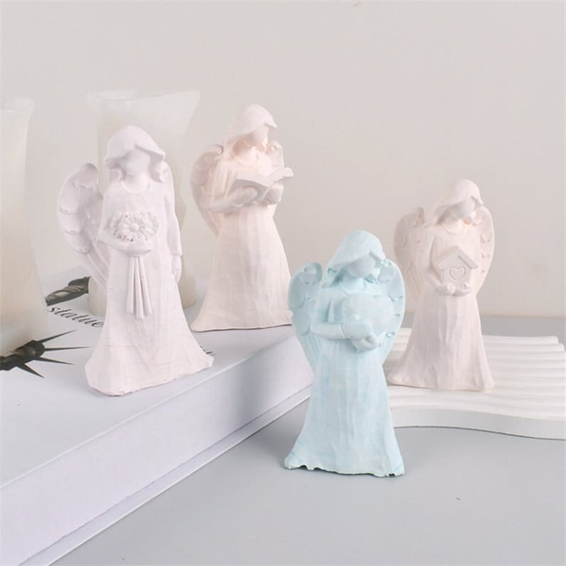 May include: Four small angel figurines, two are white, one is pale pink, and one is light blue. Each angel is holding a different object, including a book, a bird, a bouquet of flowers, and a heart.