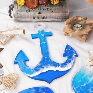 May include: A blue resin anchor with white waves, a popular nautical decor item. The anchor is a decorative piece with a resin finish.