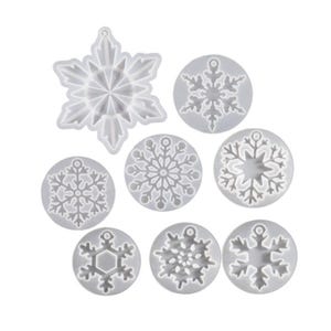 Può includere: Set di sette stampi in silicone a forma di fiocco di neve per realizzare gioielli o ornamenti in resina. Gli stampi sono bianchi e presentano diversi disegni di fiocchi di neve.