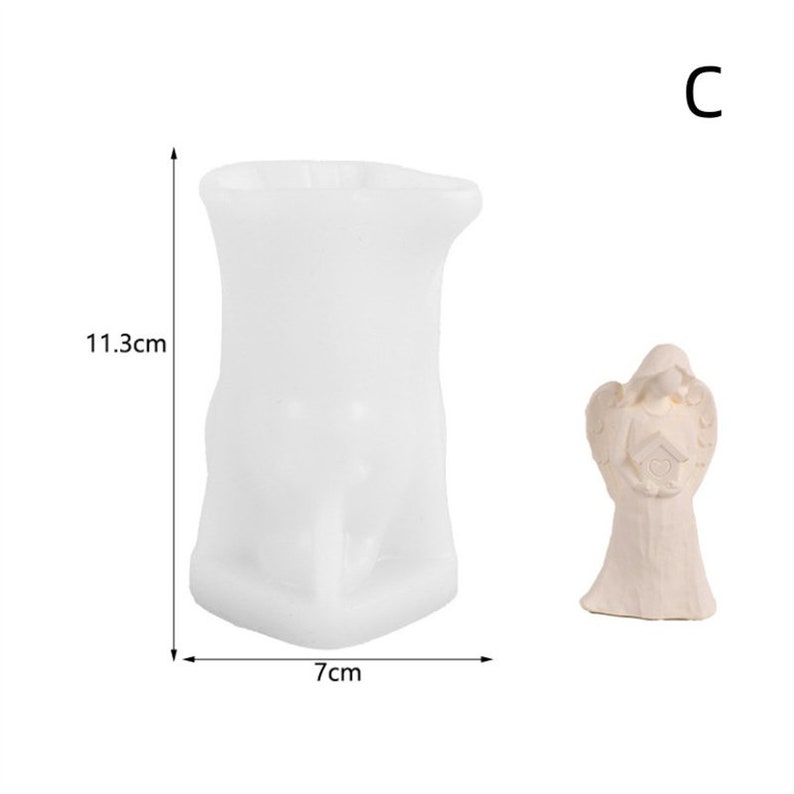 May include: White ceramic angel figurine holding a birdhouse. The figurine is 11.3 cm tall.  A white silicone mould for making candles is also shown. The mould is 11.3 cm tall and 7 cm wide.