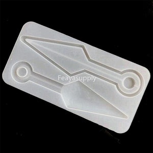 Könnte beinhalten: Weiße Silikonform zum Herstellen von zwei verschiedenen Formen von Wurfmessern. Die Form verfügt über ein größeres Messer mit einer spitzen Spitze und ein kleineres Messer mit einer abgerundeten Spitze.