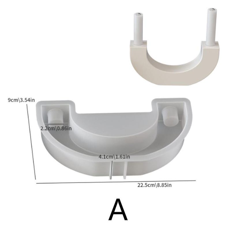 May include: A white, semi-circular mold with two cylindrical posts and a rounded base. The mold is labeled "A" and includes measurements: 22.5 inches wide, 3.54 inches high, and 1.61 inches deep. The mold is designed for crafting.