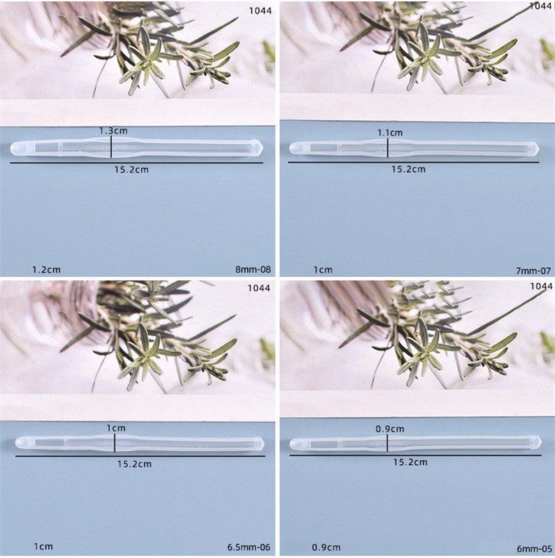 May include: Four clear plastic tubes with different lengths and widths. The tubes are measured in centimeters and millimeters. The tubes are photographed against a white background with green plants.