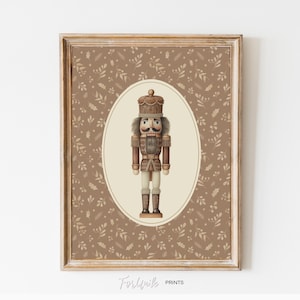Könnte beinhalten: Gerahmter Druck mit einer detaillierten Illustration eines traditionellen Nussknacker-Soldaten. Der Nussknacker ist in Braun-, Beige- und Cremetönen gehalten, mit Krone und Schnurrbart. Der Hintergrund hat ein Muster aus Blättern und Punkten in warmem Braun.