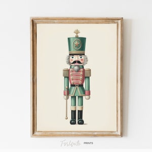 May include: A framed print of a vintage-style nutcracker soldier. The illustration features a green and pink uniform, a tall hat with a star, and a gray mustache. The print is in a gold-colored frame.