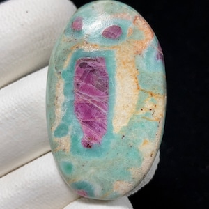 Peut inclure: Pierre précieuse ovale en cabochon avec un motif vert, blanc et rose. La partie rose est une grande forme rectangulaire verticale avec une texture striée.