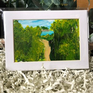 May include: A framed painting depicting a path through a woodland leading to a body of water. The painting is executed in a loose, impressionistic style with vibrant green and yellow hues.
