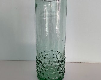 May include: A clear glass drinking glass with a textured, bubbled surface. The glass is approximately 7 inches tall.