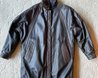 May include: A brown leather bomber jacket with a fur collar. The jacket has a zipper closure and two pockets on the front.