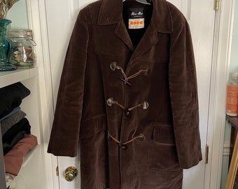 May include: A brown corduroy long coat with a toggle closure and a label that reads "Mac-Mar" and "Boro".