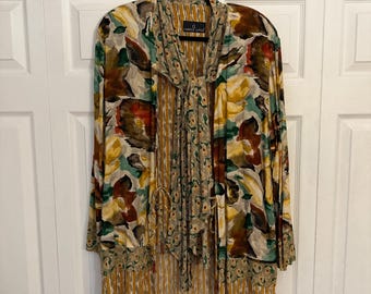 May include: A long-sleeved, floral print blouse with a tie at the neck. The blouse is made of a lightweight fabric and has a relaxed fit. The fabric features a watercolor-like design with shades of brown, green, yellow, and white.