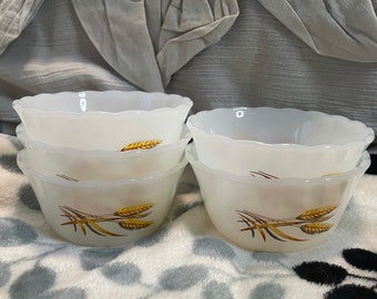May include: Set of four white ceramic bowls with a wheat design. The bowls are stacked on top of each other.