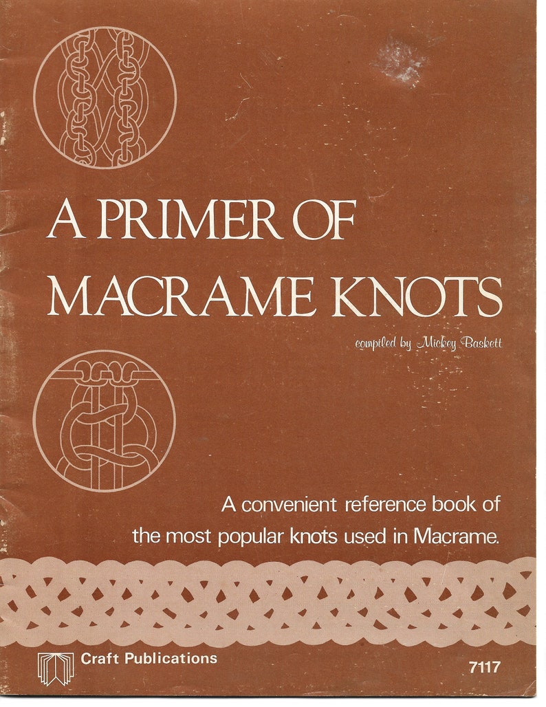 K&ouml;nnte beinhalten: Ein brauner Buchumschlag mit dem Titel "A Primer of Macrame Knots" und dem Text "compiled by Mickey Baskett". Der Umschlag zeigt auch zwei Illustrationen von Makramee-Knoten.