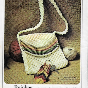 May include: A white crocheted purse with a rainbow band across the flap. The purse has a key chain attached to it. The text "Modern Jazz Key Chain Design 22" is printed below the image. The text "Rainbow A purse of many colours. The rainbow band across the flap transforms a plain and simple pattern into a lovely artistic design." is printed below the image.
