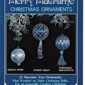 May include: A book cover with a blue background and the title "Merry Macrame Christmas Ornaments". The cover features three blue and silver macrame ornaments hanging from a snowy pine branch. The text "23 Macrame Tree Ornaments, Most Knotted on Satin Christmas Balls, For an Especially Creative Christmas" is printed below the ornaments. The author's name, "By Sylvia Carroll", and the number "#7316" are printed below the text.