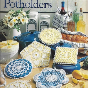 May include: A set of six crocheted potholders in white and blue, with a variety of designs. The potholders are made with bedspread weight cotton thread. The image includes the text "Pretty Crocheted Potholders" and "Designed by Linda Luder".