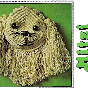 Peut inclure: Gros plan d'une sculpture de chien en fil beige avec des yeux noirs et un nez noir. Le chien s'appelle "Mitzi the Pekingese" en texte vert.