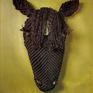 Peut inclure: Une tête de cheval brune en laine avec une bande blanche sur le visage. Le cheval a des yeux bruns et un nez noir.