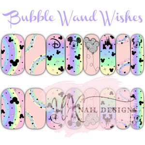 May include: Nail art sheet with various designs, including Mickey and Minnie Mouse, Disney castle silhouettes, rainbow stripes, and stars. The text "Bubble Wand Wishes" is visible. The colour scheme features pastel pink, purple, yellow, and blue. Designs are suitable for nail decoration.