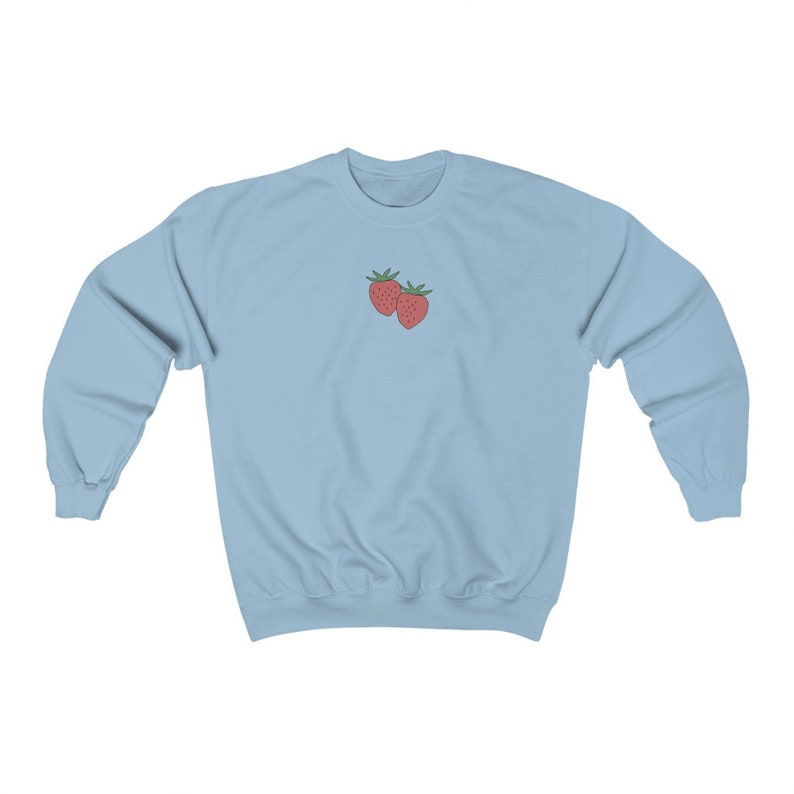 May include: A light blue sweatshirt with a small embroidered design of two red strawberries on the front.