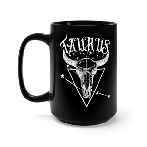 May include: Black ceramic mug with a white bull skull design and the word "Taurus" in a stylized font. The skull is surrounded by a triangle and stars.