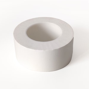 May include: A roll of white tape with a textured surface.