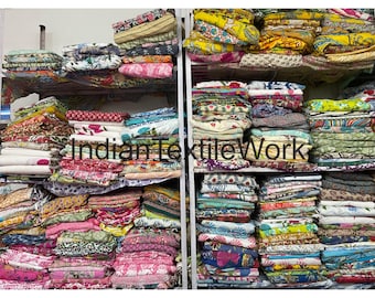Könnte beinhalten: Regale mit gefalteten Textilien in verschiedenen Farben und Mustern. Die Textilien umfassen florale, geometrische und abstrakte Designs. Der Text "Indian Textile Work" ist auf dem Bild sichtbar.