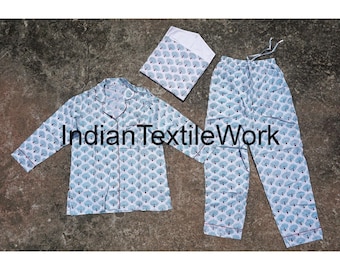 May include: A three-piece pajama set with a white background and a blue and white floral pattern. The set includes a long-sleeved shirt, pants, and a matching eye mask. The shirt has a collar and button closure. The pants have an elastic waistband. The eye mask is a simple rectangle shape. The text "Indian TextileWork" is printed on the shirt.