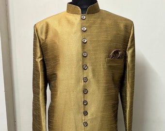 May include: A long, gold-colored, button-up jacket with a mandarin collar. The jacket has a pocket on the left side and a brown pocket square.
