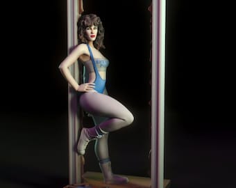 Könnte beinhalten: Eine blaue und graue Figur einer Frau in einem Trikot mit dem Text "Sherri's Perf" auf der Vorderseite, die in einem zerbrochenen Tor steht. Die Figur ist mit einem gebeugten Bein und dem anderen Bein gerade aufgestellt, die Arme an den Seiten. Die Figur steht auf einem Sockel mit einem zerbrochenen Holzstück und einem Stück Papier.