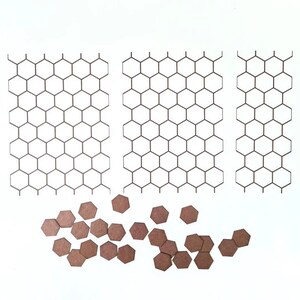 May include: Three sheets of paper with a honeycomb pattern printed on them. There are also several brown hexagonal shapes scattered on a white surface.