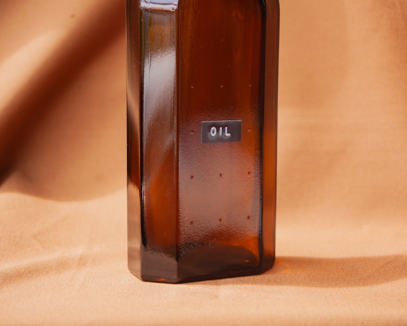 May include: A brown glass bottle with a label that says "OIL" on it.
