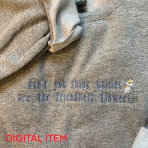 May include: Grey sweatshirt with the embroidered text "don't you think daisies are the friendliest flower?" and a small embroidered daisy.