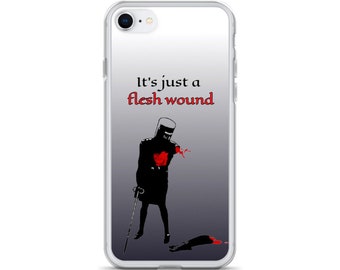 May include: A clear phone case with a black and white illustration of a knight with a red heart and the text "It's just a flesh wound".