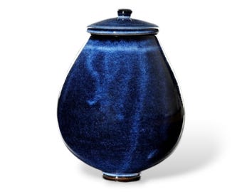 Könnte beinhalten: Eine blaue Keramikvase mit Deckel. Die Vase hat eine abgerundete, tropfenförmige Form und eine glatte, glänzende Oberfläche.