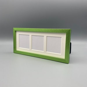 May include: A rectangular, lime green picture frame with three openings. The frame has a white matting around each opening. The frame is made of wood and has a textured finish. The frame is designed to hold three photos.