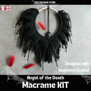 Op de afbeelding: Zwarte macramé wandhanger met een schedelbedel en rode veren accenten. De macramé heeft de vorm van vleugels en heeft een houten ring aan de bovenkant. De tekst "Angel of the Death Macrame KIT" staat onderaan de afbeelding.