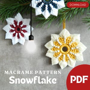 Puede incluir: Patrón de copo de nieve de macramé en PDF para descargar. Tres copos de nieve de macramé en rojo, blanco y azul, amarillo y blanco, y azul y blanco. Los copos de nieve están colgados de una rama.