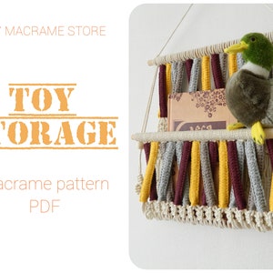 May include: DIY macrame toy storage pattern PDF. A macrame wall hanging with two shelves, made with natural cotton cord and colorful yarn. A stuffed duck toy is sitting on the top shelf.