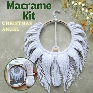 May include: White macrame Christmas angel kit with a wooden hoop, white cord, and instructions. The angel has wings and a small wooden bead for a head.