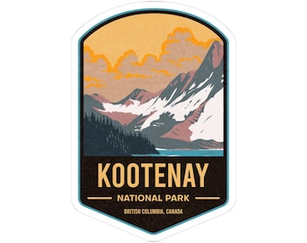 May include: A sticker featuring a mountain landscape with the text "KOOTENAY NATIONAL PARK" and "BRITISH COLUMBIA, CANADA". The design includes mountains, trees, a lake, and a sunset in shades of orange, blue, and brown.