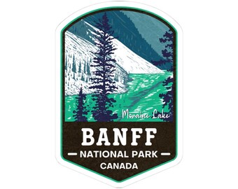 Puede incluir: Una pegatina con una ilustración del lago Moraine en el Parque Nacional Banff, Canadá. El diseño incluye un lago turquesa, montañas y árboles de hoja perenne. Se muestra el texto "Moraine Lake" y "BANFF NATIONAL PARK - CANADA".