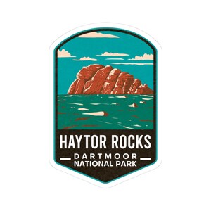 May include: A sticker featuring a landscape illustration of Haytor Rocks in Dartmoor National Park. The design includes a red rock formation, teal water, and a blue sky with white clouds. The text "HAYTOR ROCKS" and "DARTMOOR - NATIONAL PARK" are displayed.