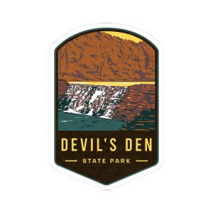May include: A sticker featuring a scenic illustration of Devil's Den State Park. The design showcases a waterfall cascading into a river, with the park's name and "State Park" text at the bottom. The color palette includes shades of brown, blue, and yellow.